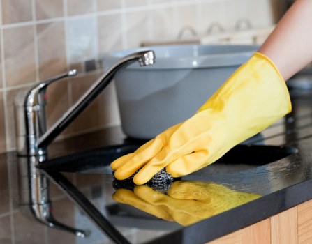 Cleaner preparing a safe home cleaning setup with protective gear