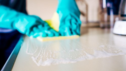Housecleaning services team cleaning kitchen and living areas